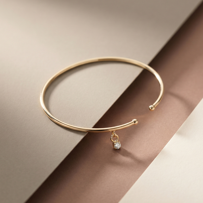 Delikatna sztywna bransoletka z podwieszaną z cyrkonią w złotym pokryciu                                    